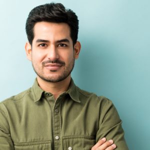 Closeup of young Hispanic man in casuals at studio